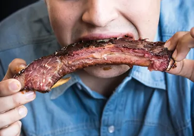 man having grilled beef ribs